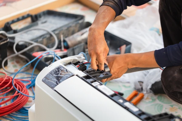 Close-up of a technician preparing connections on an indoor HVAC unit